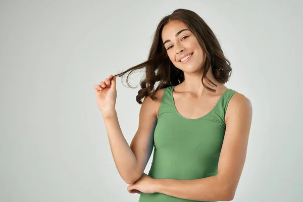Bonita morena sosteniendo su pelo peinado de moda cuidado sonrisa del año — Foto de Stock