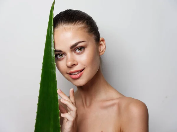 Jovem mulher limpa pele cosmetologia ombros nuos aloe folha — Fotografia de Stock