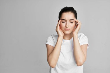 Beyaz tişörtlü kadının başı ağrıyordu.