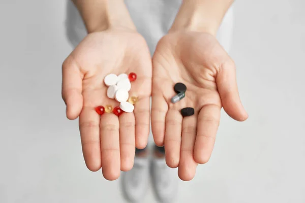 Píldoras multicolores en las palmas primer plano tratamiento medicina salud — Foto de Stock