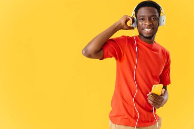 Gülümseyen Afrikalı adam kulaklık takıyor teknoloji müzik eğlencesi