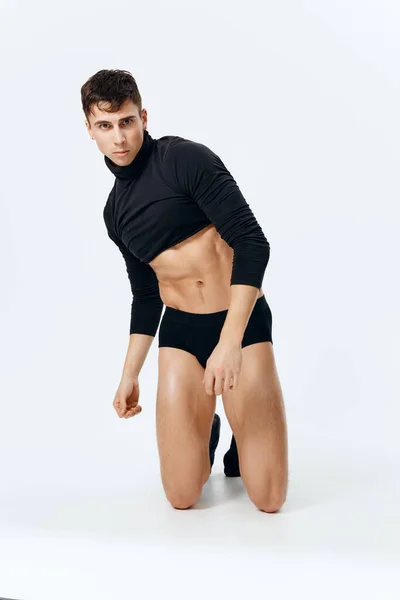 Man in shorts in a short t-shirt and socks pumped up torso striptease — Stock Photo, Image
