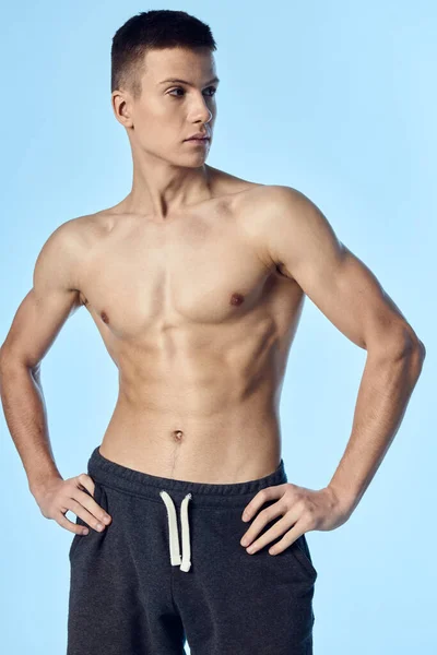 Athletic guy with a naked inflated torso holds his hands on his belt look to the side — Stock Photo, Image