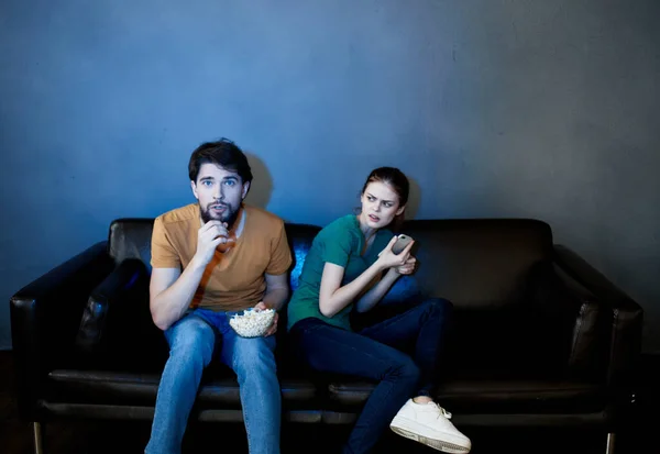 Joven familia sentada en el sofá viendo películas palomitas de maíz — Foto de Stock