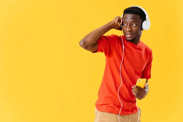 Afro-americano usando fones de ouvido estúdio de música fundo amarelo — Fotografia de Stock