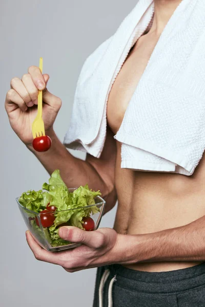 Un asciugamano sulle spalle di un uomo un piatto di insalata aspetto atletico cibo sano — Foto Stock