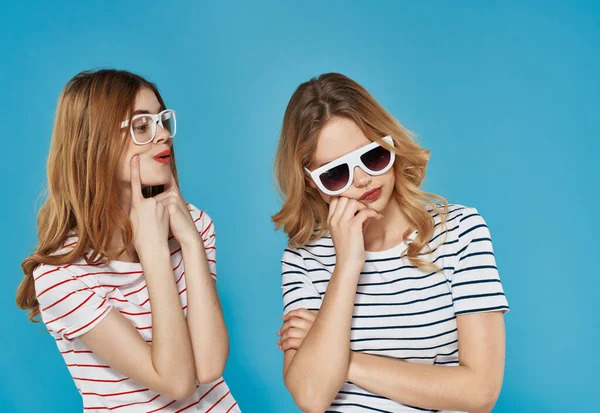 안경을 쓰고 여름 패션을 즐기는 두 명의 쾌활 한 여자 친구의 푸른 배경 — 스톡 사진