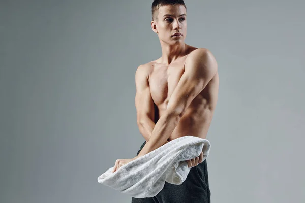 Sportig man med handduk i handen poserar muskler isolerad bakgrund — Stockfoto