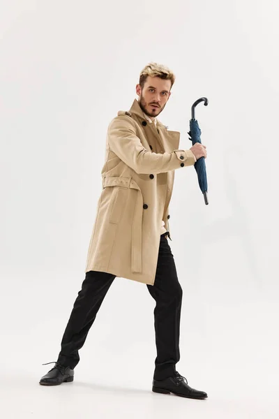 Homem em um guarda-chuva casaco em mãos posando roupas de outono estilo moderno — Fotografia de Stock