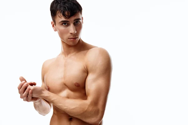 Modelo masculino con músculos bombeados de los brazos mira hacia un lado sobre un fondo blanco — Foto de Stock