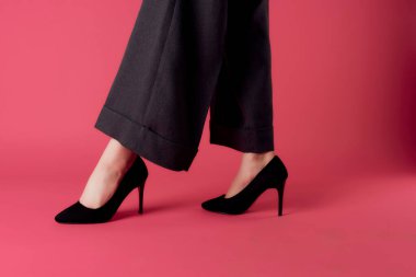 Siyah pantolonlu kadın bacakları zarif moda pozu veriyor.