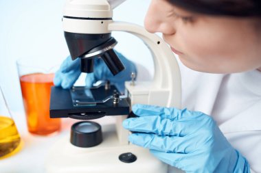 Kadın laboratuvar asistanı mikroskop araştırma mikrobiyolojisi ayarlıyor