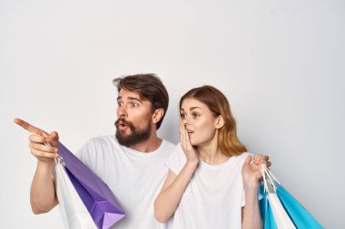 Tişörtlü genç bir çift indirimli alışveriş yapıyor.