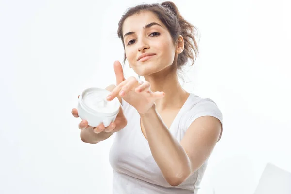 Mulher segurando um frasco de creme em suas mãos dermatologia cuidados da pele cosméticos — Fotografia de Stock