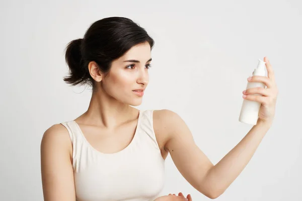 Mulher em uma camiseta branca sentou-se em suas mãos hidratando cuidados com a pele — Fotografia de Stock