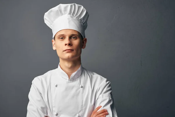 Maschio chef in un berretto bianco tiene le mani di fronte a lui professionisti di fiducia in se stessi — Foto Stock