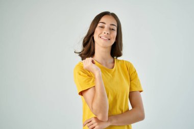 Sarı tişörtlü neşeli esmer poz veren gülümseme izole edilmiş arka plan.