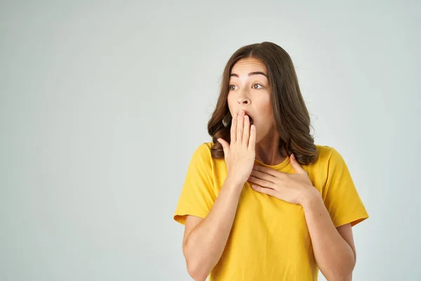 Эмоциональная женщина в желтой футболке с сюрпризом открытого рта — стоковое фото
