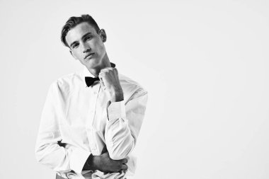 Beyaz gömlekli adam papyon görünümlü stüdyo manzaralı.