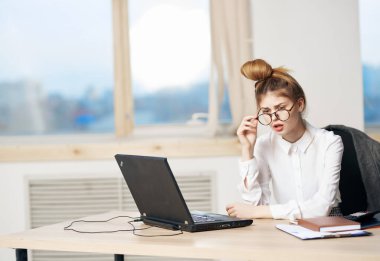 Güzel kadın sekreter dizüstü bilgisayarda çalışıyor duygular çalışıyor