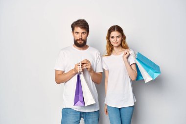 Beyaz tişörtlü genç çift eğlence indirimi yapıyor.