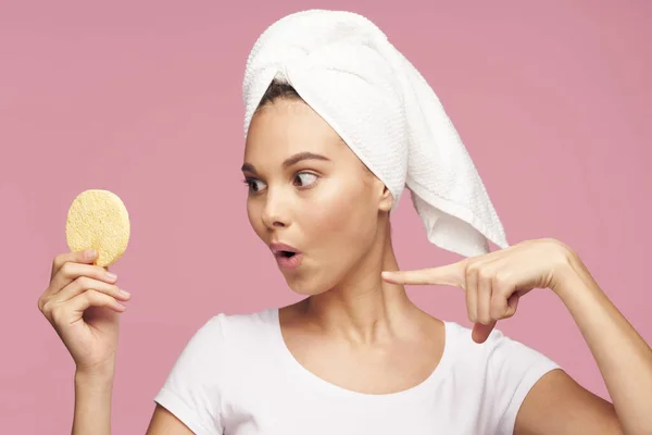 Vrouw met een handdoek op haar hoofd schone huid spons in haar handen — Stockfoto