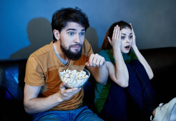 Mann und Frau abends zu Hause auf der Couch vor dem Fernseher — Stockfoto