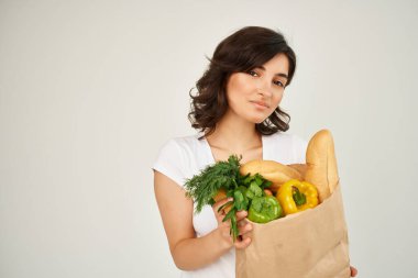 Marketin arka planında alışveriş paketi olan neşeli bir kadın.