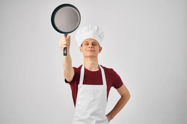 Egy szakácsegyenruhás férfi serpenyőt süt a főzés kezében. — Stock Fotó