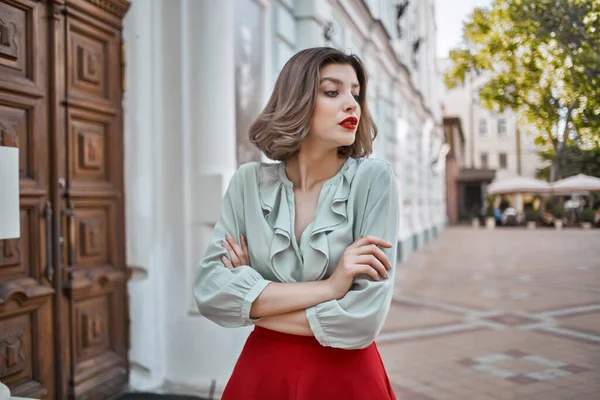 Mignonne fille blonde avec des lèvres rouges à l'extérieur marcher près du bâtiment — Photo