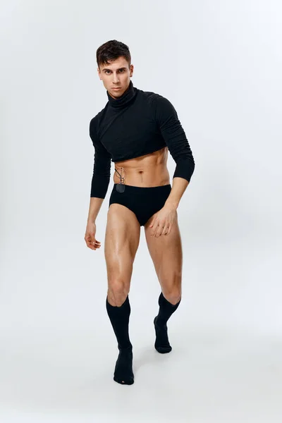 Retrato de um homem em pleno crescimento, inflado torso fisiculturista fitness cuecas e meias de joelho de camisola preta — Fotografia de Stock