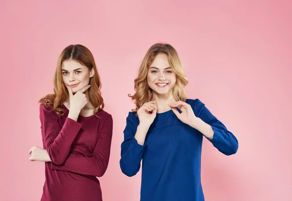 Glada flickvänner i klänningar skönhet mode rosa bakgrund — Stockfoto