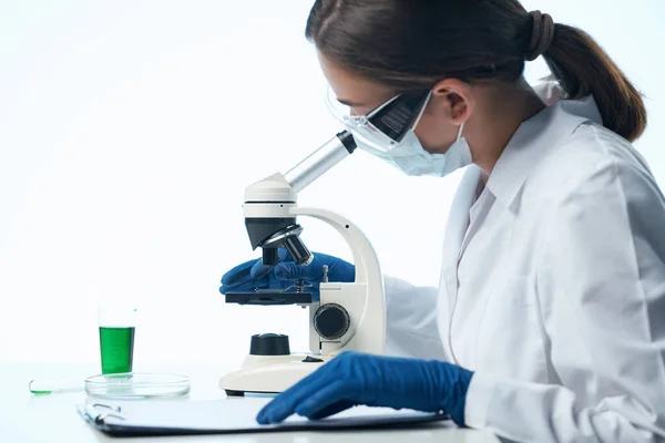 Donna scienziata guardando attraverso un microscopio ricerca biologia diagnostica — Foto Stock