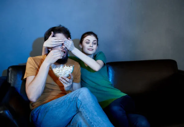 Сім'я сидить на дивані ввечері дивиться телевізор з попкорн розваги — стокове фото