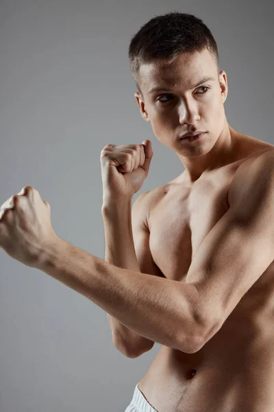 Pohledný sportovec s nahý trup na šedém pozadí a biceps kulturista — Stock fotografie