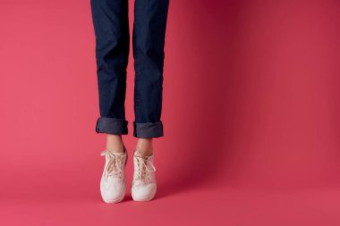 Pembe arka plan pozu veren kadın ayakkabıları kırpılmış