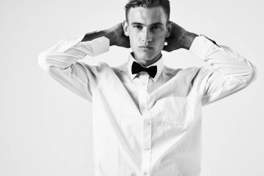 Beyaz gömlekli, papyonlu, saç modelli bir adam.