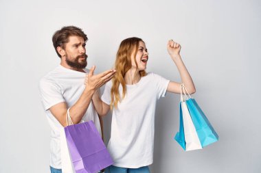 Ellerinde paketler, alışveriş eğlencesi olan genç bir çift.