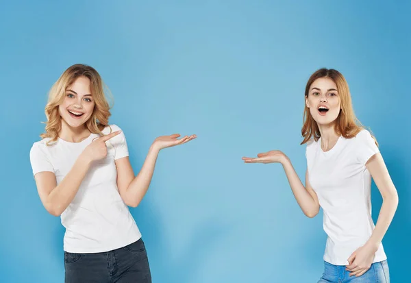 Duas mulheres em t-shirts brancas amizade comunicação azul fundo — Fotografia de Stock