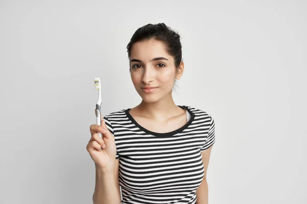 Morena em uma camiseta listrada escovando os dentes close-up — Fotografia de Stock