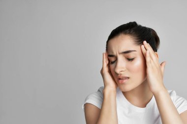 Başı ağrıyan esmer, duygularını tutan migren rahatsızlığı olan.