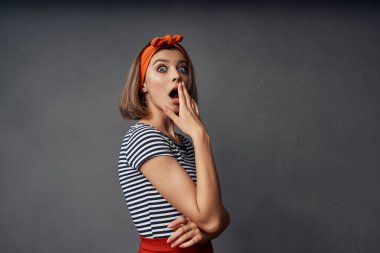 Turuncu saç bandıyla şık bir kadın modern kıyafetler koyu arka plan