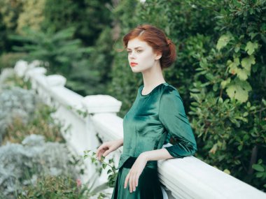 Yeşil elbiseli çekici bir kadın. Kırmızı dudaklı. Park yazı.