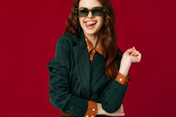Γυναίκα σε κοστούμι γυαλιά ηλίου χαμόγελο περικοπή προβολή κόκκινο φόντο στούντιο — Φωτογραφία Αρχείου