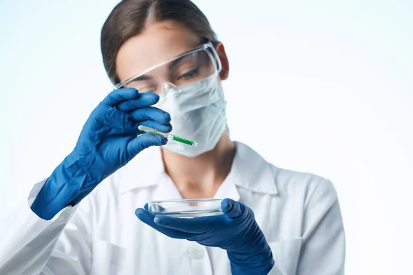 Assistente de laboratório em uma pesquisa máscara médica casaco branco analisa — Fotografia de Stock