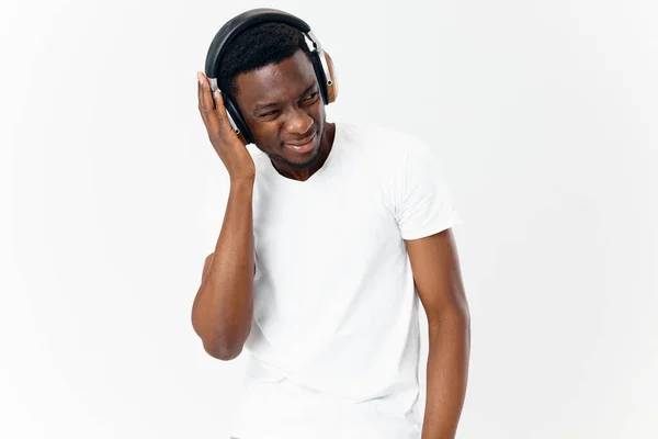 Beyaz tişörtlü, kulaklıklı, müzik teknolojisi stüdyosu dinleyen Afrikalı bir adam. — Stok fotoğraf