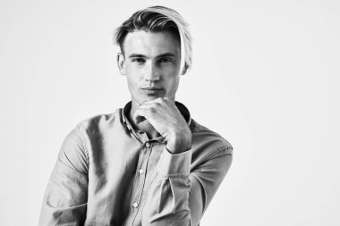 Tişörtlü bir adam. Moda tarzı bir stüdyo. Siyah beyaz fotoğraf.