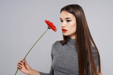 Güzel esmer, kırmızı çiçekli parlak makyaj modeli.