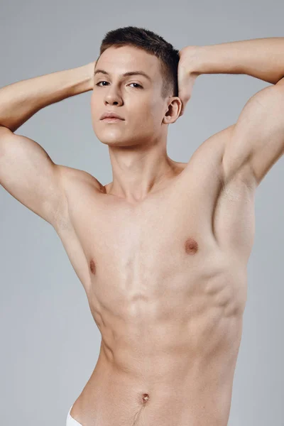 Handsome man with pumped up muscles holds his hands behind his head cropped view Copy Space — Stock Photo, Image