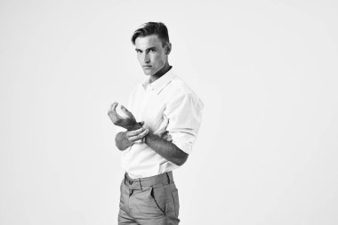 Beyaz gömlekli, şık saç stili, stüdyo manzaralı bir adam.